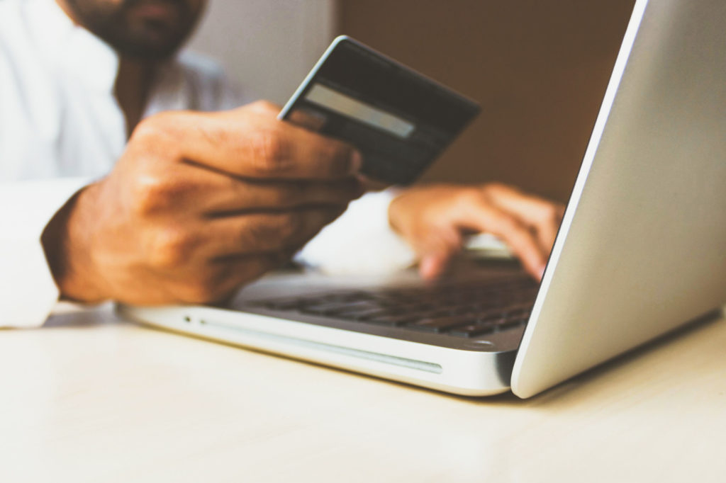 Business man inputting credit card information into a laptop